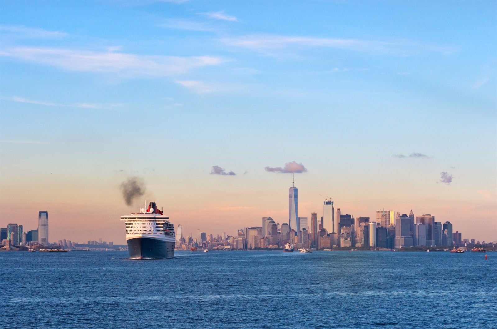 Ocean liner sailing past the Manhattan skyline in the evening light